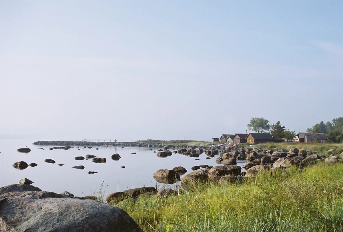 Misty Estonian coastline with granite boulders in calm water